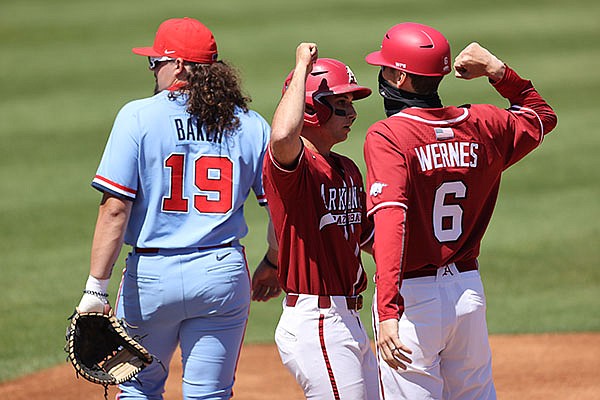 Ole Miss first baseman Cael Baker (left) looks away as Arkansas second baseman Robert Moore (center) celebrates with first base coach Bobby Wernes during a game Sunday, April 11, 2021, in Oxford, Miss. (Photo courtesy Ole Miss Athletics, via SEC pool)