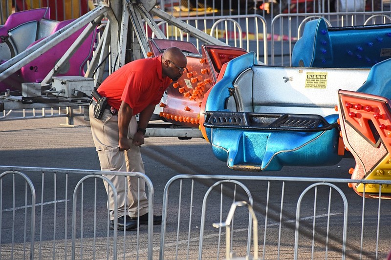 An official with the Little Rock Police Department investigates a shooting Saturday, April 10, 2021, at the Outlets of Little Rock Carnival in the shopping mall's parking lot. (Arkansas Democrat-Gazette/Staci Vandagriff)