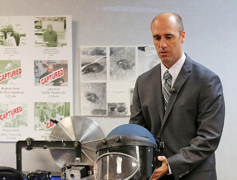 Special Agent Ryan Kennedy of the FBI’s Little Rock office shows a bomb-blast helmet in the office in this October 2015 file photo. (Arkansas Democrat-Gazette file photo)