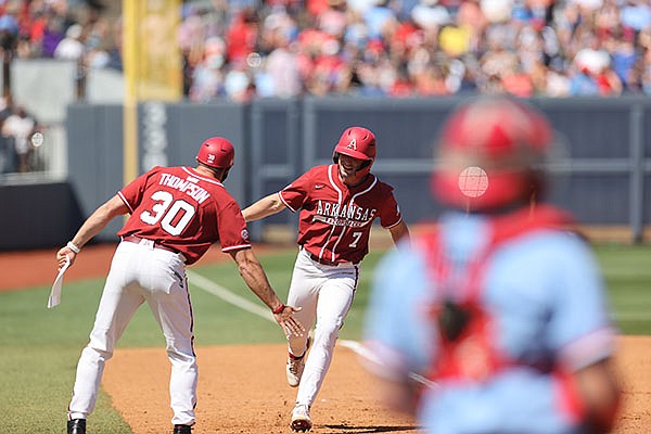 Arkansas' Cayden Wallace (7) is congratulated by hitting coach Nate Thompson as he rounds the bases after hitting a home run during a game against Ole Miss on Sunday, April 11, 2021, in Oxford, Miss. (Photo courtesy Ole Miss Athletics, via SEC pool)