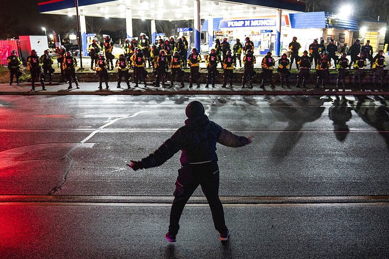 A demonstrator heckles authorities who advanced into a gas station after issuing orders for crowds to disperse during a protest against the police shooting of Daunte Wright, late Monday, April 12, 2021, in Brooklyn Center, Minn. (AP/John Minchillo)