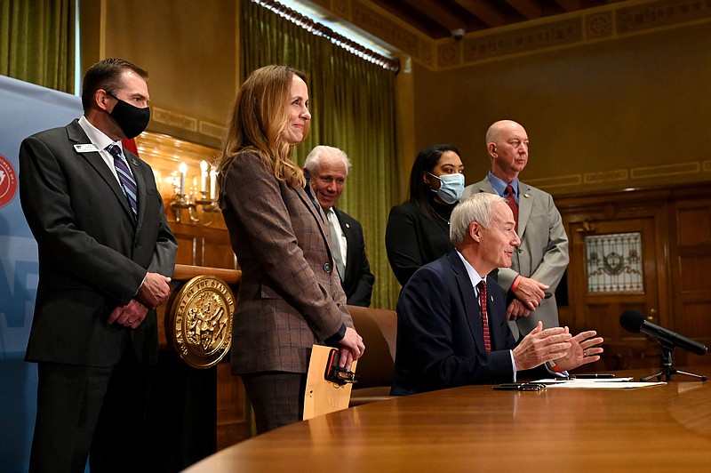 Governor Hutchinson, surrounded by legislators and educators from Arkansas, signs teacher salary bills SB504 and HB1614 during a press conference at the Arkansas State Capitol on Monday, April 12. The bills will increase the target median salary for teachers to $52,822, an increase of $2,000, Hutchinson said. (Arkansas Democrat-Gazette/Stephen Swofford)