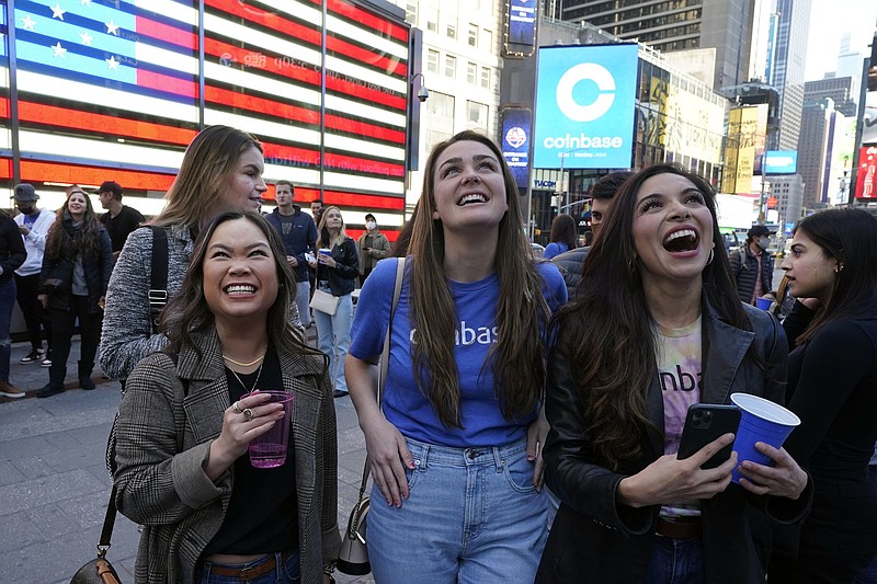 Coinbase employees celebrate Wednesday outside the Nasdaq MarketSite in New York’s Times Square as the digital currency exchange became a publicly traded company.
(AP/Richard Drew)