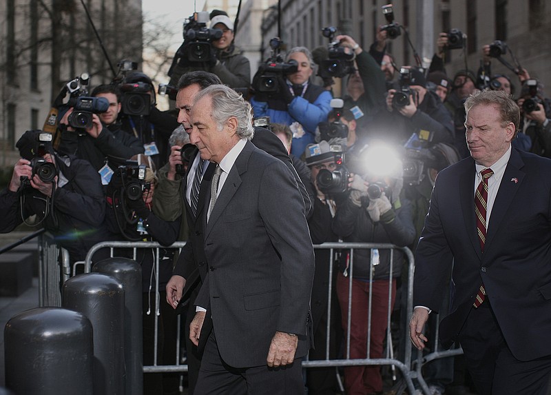 Bernard Madoff (center) arrives March 12, 2009, at federal court in New York to plead guilty to securities fraud and other charges. He and his family had lived a lavish lifestyle with investors’ money until 2008, when he confessed to his sons that his business was “all just one big lie.”
(The New York Times/file photo)