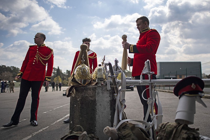 A soldier  from  the Household Calvary Life Guards prepares his uniform Wednesday on  the drill square at the Army Training Centre Pirbright in Woking, Surrey, England, before rehearsing for the funeral of Britain’s Prince Philip.
(PA/AP/Victoria Jones)