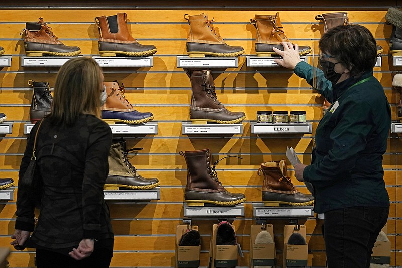 An employee helps a customer shop for Bean Boots last month at the L.L. Bean flagship retail store in Freeport, Maine. Retail sales surged a seasonally adjusted 9.8% in March, the Commerce Department said Thursday.
(AP)