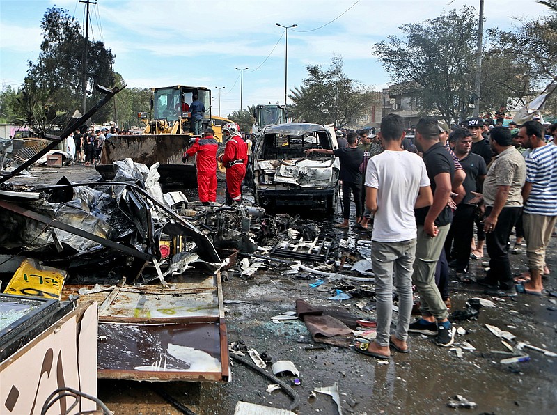 People check out the scene of an explosion Thursday in a crowded outdoor used-furniture market in Baghdad. More photos at arkansasonline.com/416sadr/.
(AP/Khalid Mohammed)