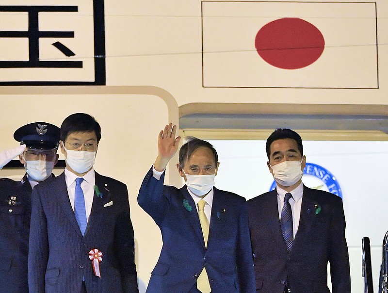 “I hope to develop a relationship of trust with President Biden,” Japanese Prime Minister Yoshihide Suga (center) said Thursday as he leaves Tokyo for the U.S. Suga will be the first foreign leader to have face-to-face talks with President Joe Biden.
(AP/Kyodo News)