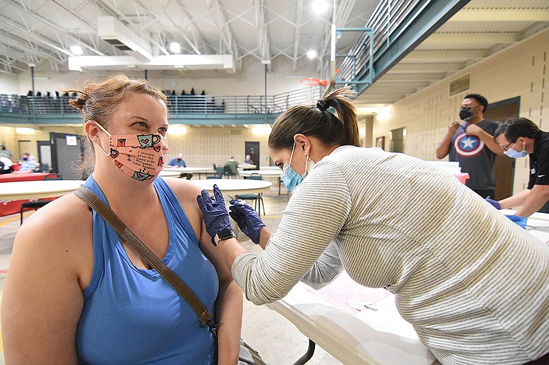 Michelle Edmonds of Little Rock (left) gets her second dose of the Moderna coronavirus vaccine from Jennifer Crumbaugh, a pharmacist for Express Rx, on Thursday at Henderson United Methodist Church in Little Rock..(Arkansas Democrat-Gazette/Staci Vandagriff)