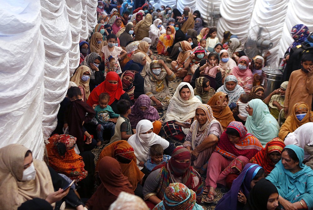 Women wait to receive food assistance for the Muslim fasting month of Ramadan, in Lahore, Pakistan on April 10. Muslims are facing their second Ramadan in the shadow of the pandemic.
(AP/K.M. Chaudary)