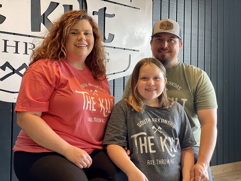 Angela Thomas, daughter Madelyn Johnson, and Ryan Thomas all wear their The Kilt t-shirts inside the recently opened axe throwing facility at 2006 North West Avenue. (Marvin Richards/News-Times)