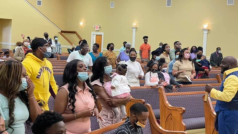 Apostle Christopher Mack of Highland Baptist Church in Pine Bluff (right) delivers a sermon to his congregation on Easter Sunday. On Easter last year, his pews were empty because of the covid-19 pandemic. 
(Special to the Commercial)