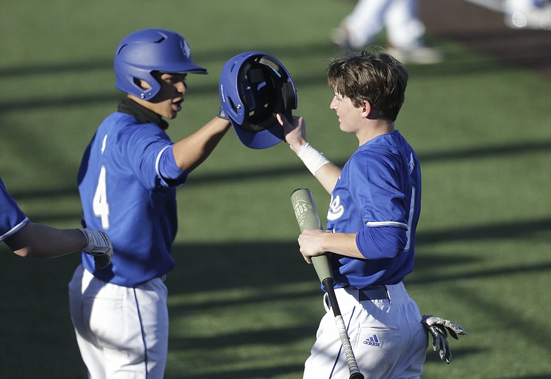 Rogers JT Melson (1) returns to the dugout following a score, Monday, April 19, 2021 during a baseball game at Rogers High School in Rogers. Check out nwaonline.com/210420Daily/ for today's photo gallery. 
(NWA Democrat-Gazette/Charlie Kaijo)