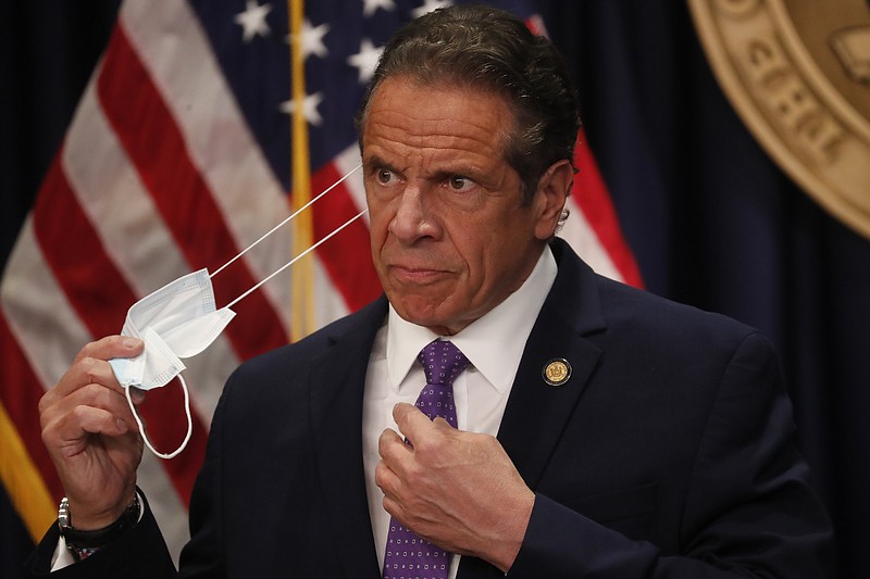 Gov. Andrew Cuomo takes off his face mask before a news conference in New York on Monday, April 19, 2021. New York’s comptroller has asked the state attorney general’s office to launch a criminal investigation into whether the governor used state resources to write and promote his book on leadership in the COVID-19 pandemic.