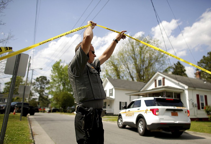 Law enforcement investigate the scene of a shooting in Elizabeth City, N.C., on Wednesday, April 21, 2021. At least one law enforcement officer with a sheriff's office in North Carolina shot and killed a man while executing a search warrant Wednesday, the sheriff's office said. (Stephen M. Katz/The Virginian-Pilot via AP)