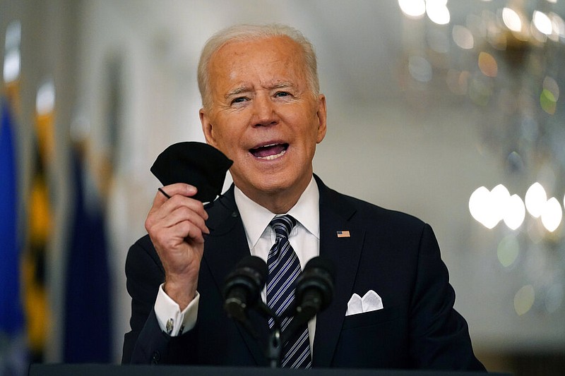 FILE - In this March 11, 2021, file photo, President Joe Biden holds up his face mask as he speaks about the covid-19 pandemic during a prime-time address from the East Room of the White House in Washington. (AP/Andrew Harnik, File)