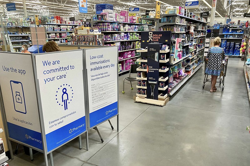 A worker (left) gives a covid-19 vaccination inside a cubicle while a woman shops at a Walmart store in Haleyville, Ala., earlier this month.
(AP/Jay Reeves)