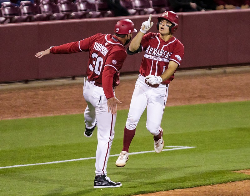 Arkansas’ Robert Moore (right) is congratulated by third-base coach Nate Thompson after hitting his second home run during the Razorbacks’ victory over South Carolina on Thursday night in Columbia, S.C. Moore finished 2 for 4 with 3 RBI.
(South Carolina Athletics/Jeff Blake)