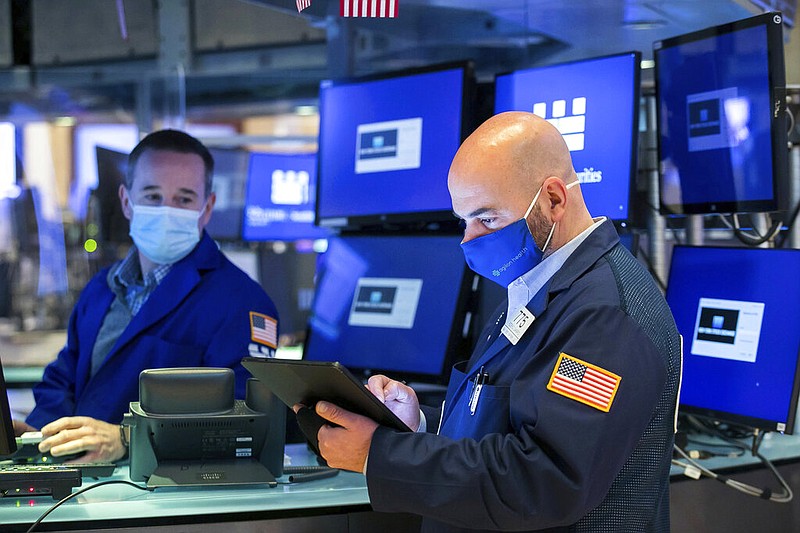 In this photo provided by the New York Stock Exchange, trader Fred DeMarco, right, works on the floor, Thursday April 22, 2021. (Courtney Crow/New York Stock Exchange via AP)