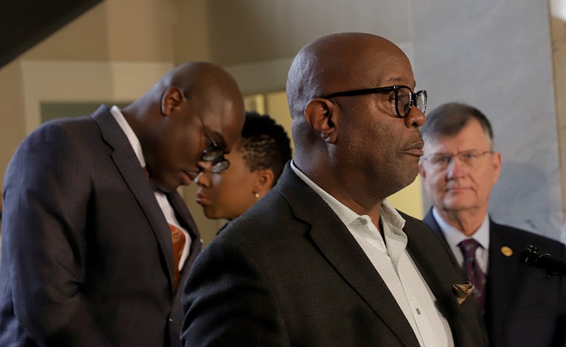 Little Rock Mayor Frank Scott Jr. (left) huddles with Stephanie Jackson, his communications director, while Little Rock Police Chief Keith Humphrey (foreground) speaks during a news conference held in the lobby of Little Rock's City Hall in this March 16, 2020, file photo. (Arkansas Democrat-Gazette file photo)