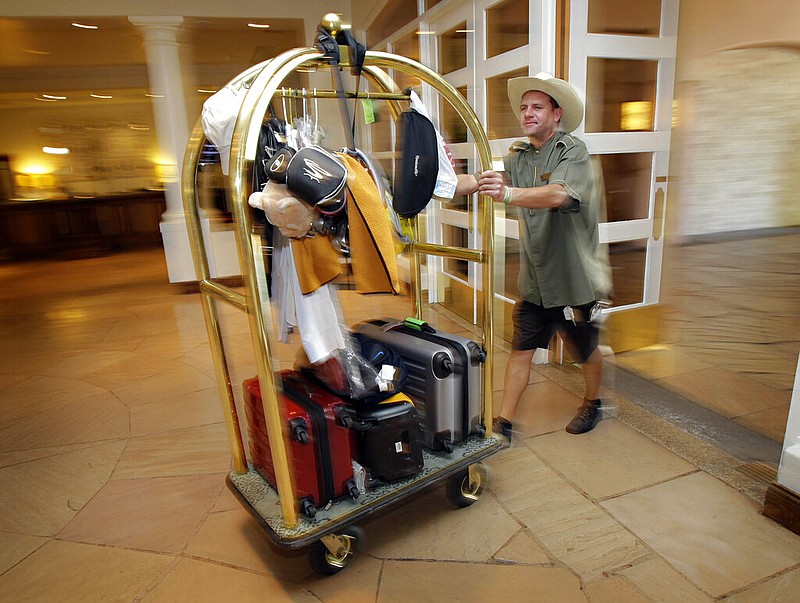 A bellhop transports luggage for guests at a hotel in this October 2010 file photo. (AP/Matt York)
