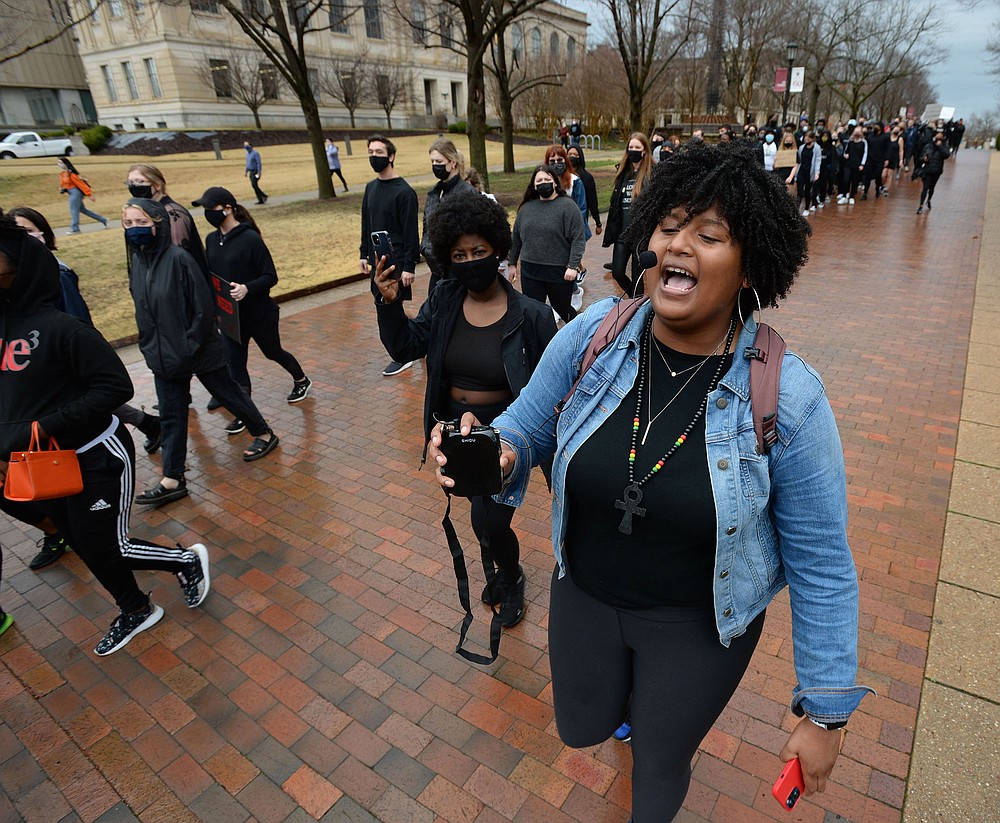 Tyrah Jackson (right) of Pine Bluff, a student at the University of Arkansas, Fayetteville, leads a group of students and members of the campus community on a march last month to call for the school to disassociate from J. William Fulbright and Charles Brough.
(NWA Democrat-Gazette/Andy Shupe)