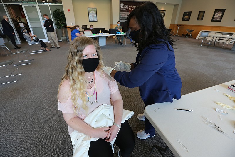 University of Arkansas at Little Rock PhD student Lacey Roughton gets her first dose of the Pfizer vaccine from UALR nursing instructor, Shelia Brooks, during UALR's vaccine clinic put on by Don's Pharmacy on Wednesday, April 28, 2021, at the Jack Stephens Center in Little Rock. (Arkansas Democrat-Gazette/Thomas Metthe)