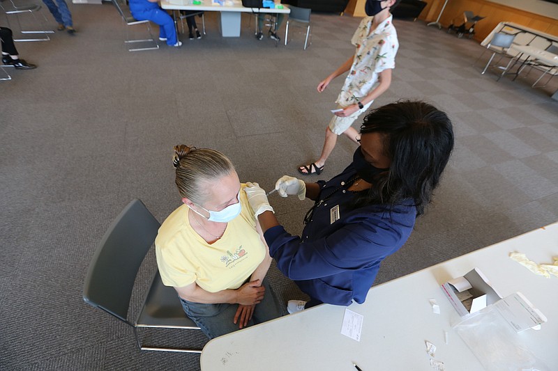 Kathy Davidson gets her first dose of the Pfizer vaccine from UALR nursing instructor Shelia Brooks during UALR's vaccine clinic put on by Don's Pharmacy on Wednesday, April 28, 2021, at the Jack Stephens Center in Little Rock. (Arkansas Democrat-Gazette/Thomas Metthe)