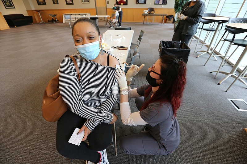 Mia Hampton gets her first dose of the Pfizer vaccine from Jami De La Cruz, a senior nursing student at UALR, during UALR's vaccine clinic put on by Don's Pharmacy on Wednesday, April 28, 2021, at the Jack Stephens Center in Little Rock. (Arkansas Democrat-Gazette/Thomas Metthe)