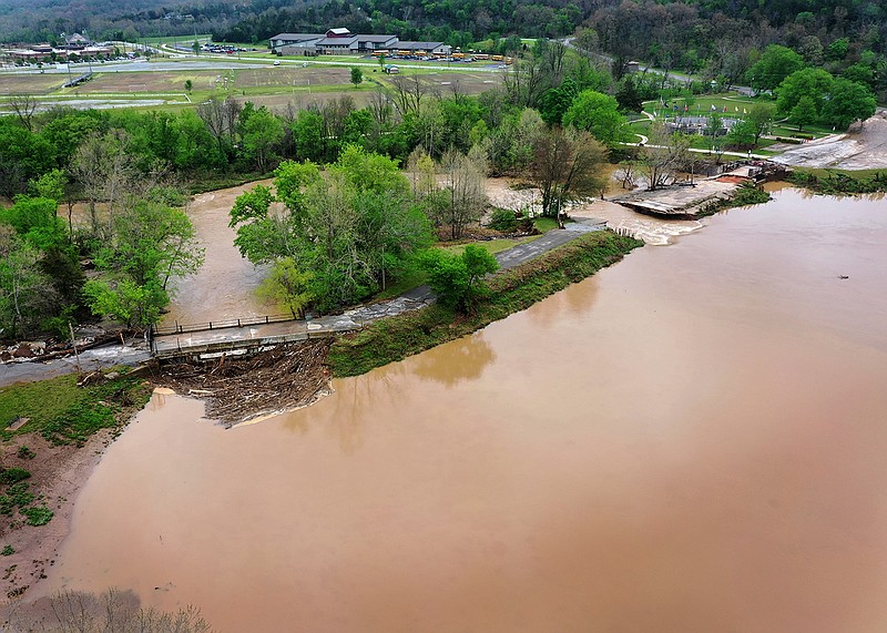 A section of the dam that creates Lake Bella Vista was washed away in Wednesday’s storms. The break is in a section between two concrete overflows. The main dam gate and overflows became blocked by debris, authorities said.
(NWA Democrat-Gazette/Spencer Tirey)