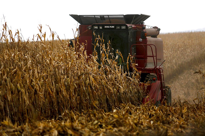A farmer harvests crops near Sinsinawa Mound in Wisconsin in this Dec. 4, 2017, file photo. A group of Midwestern farmers sued the federal government Thursday, April 29, 2021, alleging they can't participate in a covid-19 loan forgiveness program because they're white. The group of plaintiffs includes farmers from Wisconsin, Minnesota, South Dakota and Ohio. (Eileen Meslar/Telegraph Herald via AP)