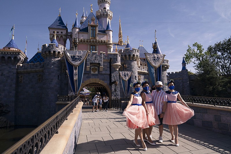 Visitors take pictures Friday in front of the Sleeping Beauty Castle at Disneyland in Anaheim, Calif. The Southern California theme park that had been closed under the state’s strict virus rules reopened Friday, inspiring some visitors to cheer and scream with happiness.
(AP/Jae C. Hong)