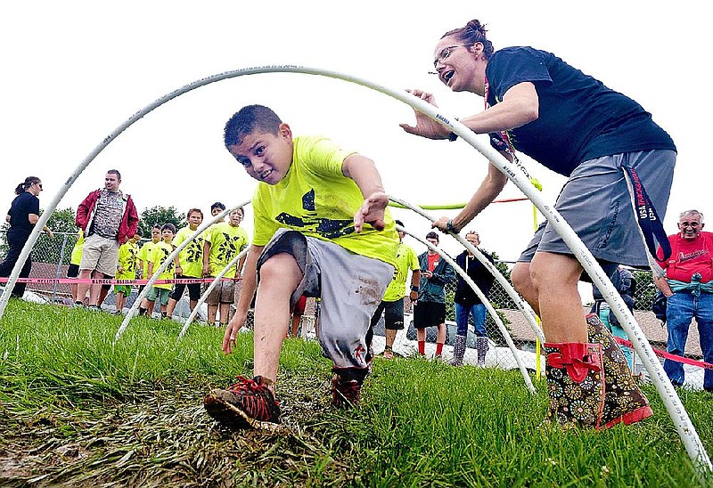 Stephanie Kerkhover, a physical education instructional assistant at Parson Hills Elementary in Springdale, cheers on Ronny Estrada at the school in this May 30, 2015, file photo. (NWA Democrat-Gazette file photo)