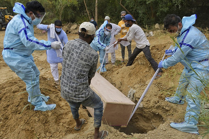 Relatives bury the body of a covid-19 victim at a graveyard in New Delhi, India, Tuesday, May 4, 2021. (AP/Ishant Chauhan)
