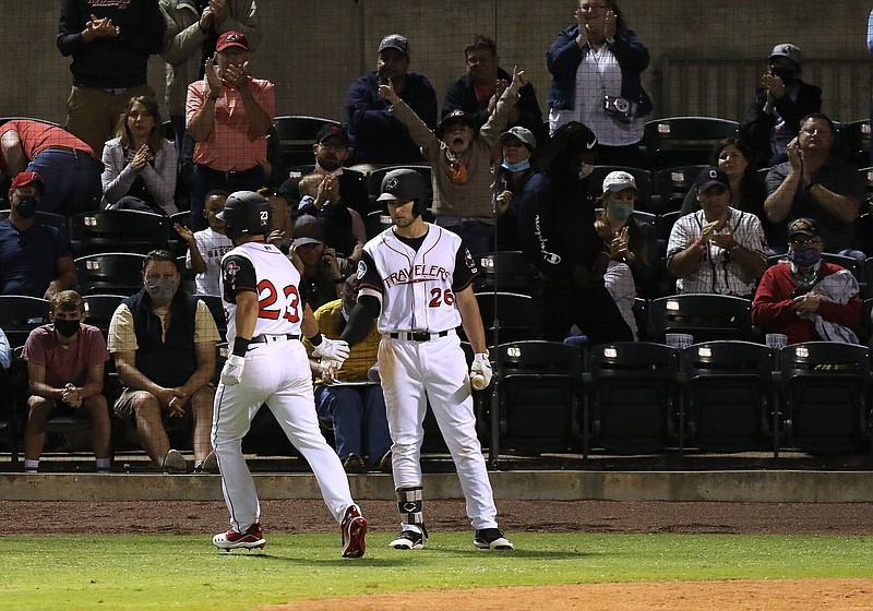 Fans cheer as Arkansas Travelers' Jake Scheiner (23) is congratulated by teammate Keegan McGovern (26) after Scheiner hit a home run during the bottom of the fourth inning of the Travelers home opener on Tuesday, May 4, 2021, at Dickey-Stephens Park in North Little Rock. .More photos at www.arkansasonline.com/55travs/.(Arkansas Democrat-Gazette/Thomas Metthe)