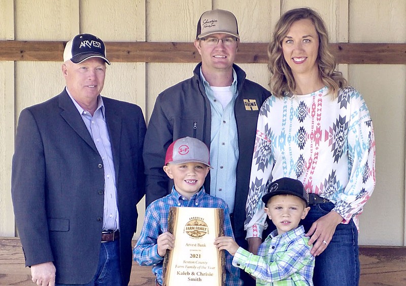 Jim Singleton (left), chairman of the Benton County Farm Family of the Year selection committee, presented the 2021 Benton Farm Family of the Year plaque to Kaleb and Chrisie Smith of Gentry, along with their two boys, Paden, 7, and Paxton, 5, at their farm near Gentry on Wednesday.
(NWA Democrat-Gazette/Randy Moll)
