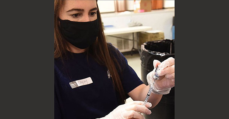 Cayley McCollough of Collier Drug Stores prepares Pfizer doses Wednesday at the Benton County Fairgrounds auditorium at a clinic in partnership with Benton County and Collier Drug Stores.
(NWA Democrat-Gazette/Flip Putthoff)