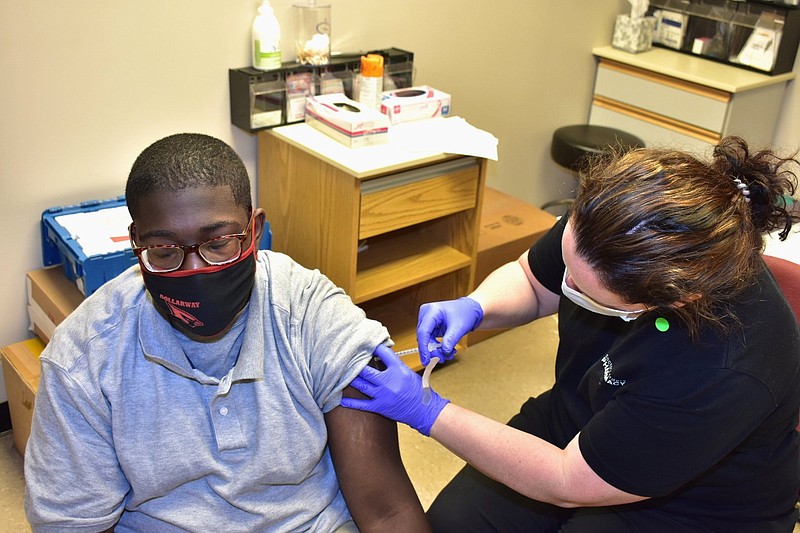 Timothy Bailey, 17, a junior at Dollarway High School, gets his second covid-19 shot from Doctor’s Orders pharmacist Sarah Stephenson on campus Thursday. 
(Pine Bluff Commercial/I.C. Murrell)