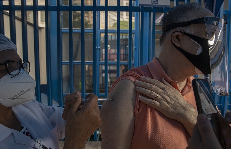 A health worker administers a Pfizer covid-19 vaccination Thursday at a community medical center in Sao Paulo. Brazil Health Minister Marcelo Queiroga said he fears the country lacks the means to produce vaccines and that lifting patent protections could interfere with efforts to buy doses from pharmaceutical companies.
(AP/Andre Penner)