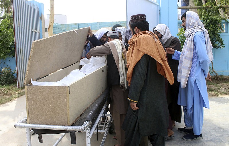 In Kandahar, Afghans mourn over the body of Nimat Rawan, a former Afghan TV presenter who was gunned down Thursday.
(AP/Sidiqullah Khan)