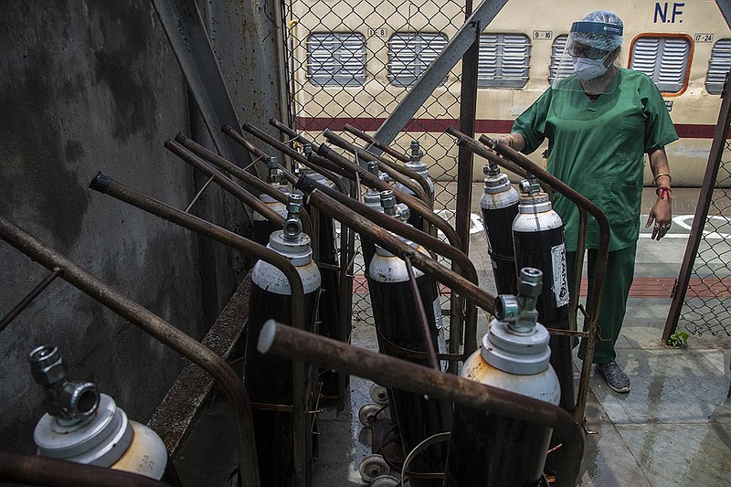 A health worker checks oxygen cylinders Thursday next to a train that’s being used as a covid-19 care center in Gawahati, India. Demand  for oxygen has increased sevenfold there in the past month as coronavirus cases rise across India.
(AP/Anupam Nath)