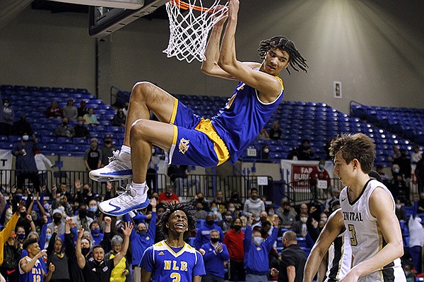 North Little Rock's Kel'el Ware (10) hangs on the rim after a dunk during the fourth quarter of the Charging Wildcats' 65-55 win in the Class 6A boys state championship game on Thursday, March 18, 2021, at Bank OZK Arena in Hot Springs.