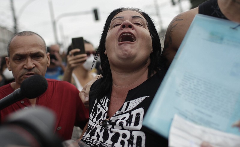 A relative of a person killed Thursday when police raided a slum in Rio de Janeiro joins Friday in protesting the police actions that left 25 people dead.
(AP/Silvia Izquierdo)