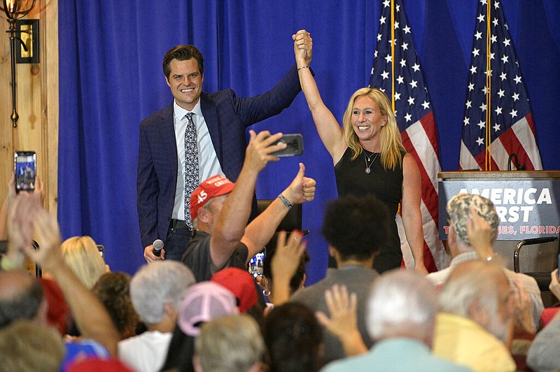 U.S. Rep. Matt Gaetz (left), R-Fla., and U.S. Rep. Marjorie Taylor Greene, R-Ga., raise their arms after addressing attendees of a rally in The Villages, Fla., on Friday, May 7, 2021. (AP/Phelan M. Ebenhack)