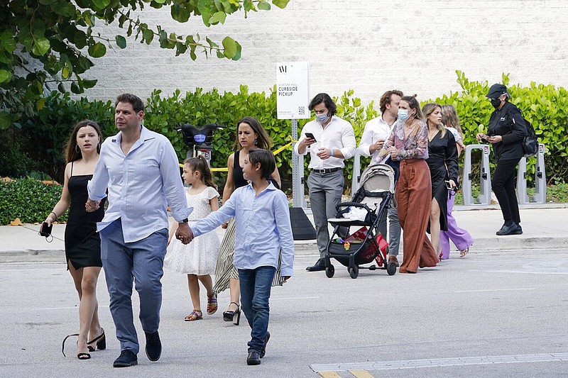 Shoppers who were hiding in stores exit the Aventura Mall in Aventura, Fla., on Saturday, May 8, 2021, after a shooting left three people injured and several suspects in custody. Officers with the Aventura Police Department said two groups of people had begun fighting in the mall when shots rang out. (AP/Marta Lavandier)