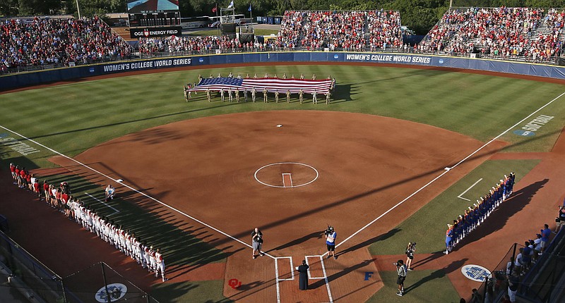 A large flag is unfurled in the outfield before the second game of the best-of-three championship series between Florida and Oklahoma in the NCAA Women’s College World Series in Oklahoma City in this 2017 file photo. The NCAA has reached a delicate moment: It must decide whether to punish states that have passed laws limiting the participation of transgender athletes by barring them from hosting its softball and baseball tournaments. (AP Photo/Sue Ogrocki, File)