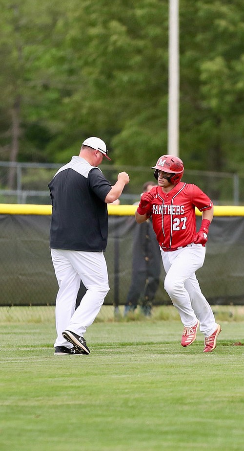 Magnolia’s Dalen Blanchard gives head coach Bobby Beeson a fist bump. The catcher has hit a home run in two of the Panthers’ last three games, including Friday’s 11-1 regional semifinal win over Bauxite. (Photo by Bill Nielsen)