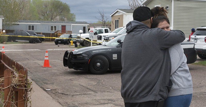 People comfort each other down the street from the scene of a shooting in Colorado Springs, Colo., on Sunday, May 9, 2021. The suspected shooter was the boyfriend of a female victim at the party attended by friends, family and children, police said. (Jerilee Bennett/The Gazette via AP)