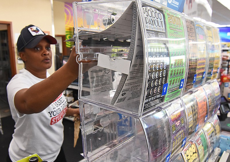 Cashier Sekoiyn Phillips pulls lottery scratch-off tickets for a customer Wednesday at the Corner Store on Stagecoach Road in Little Rock.
(Arkansas Democrat-Gazette/Staci Vandagriff)