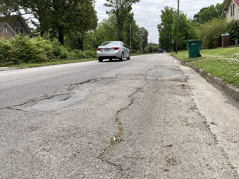 A car passes one of the many places along Cherry Street where signs of wear are evident. 
(Pine Bluff Commercial/Byron Tate)